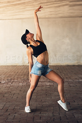 Buy stock photo Shot of an attractive young female street dancer practising out in the city