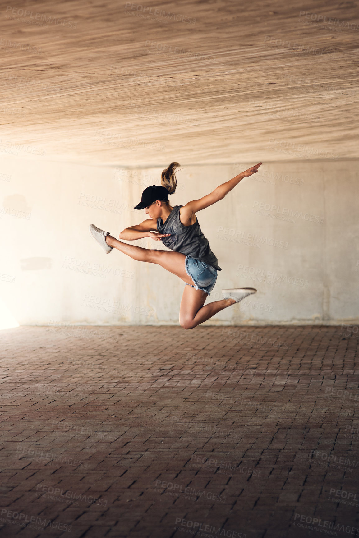 Buy stock photo Shot of an attractive young female street dancer practising out in the city