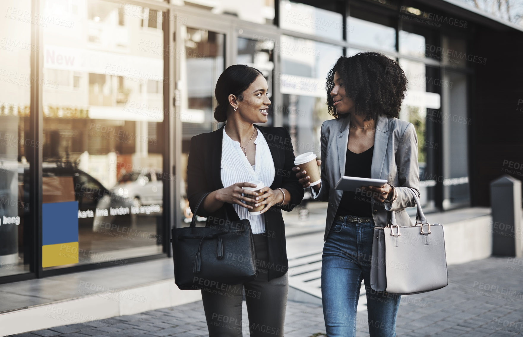 Buy stock photo Shot of two businesswomen having a discussion while walking in the city