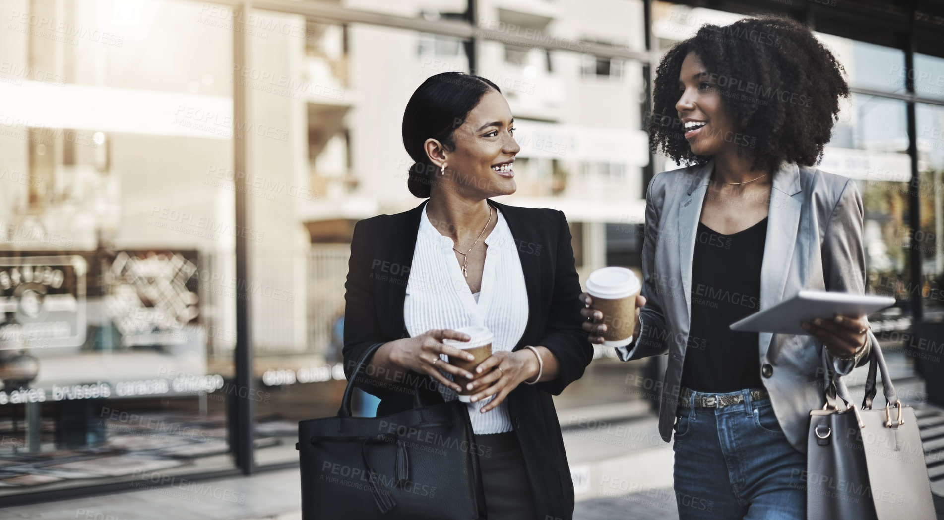 Buy stock photo Shot of two businesswomen having a discussion while walking in the city