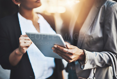Buy stock photo Closeup shot of two businesswomen using a digital tablet in the city