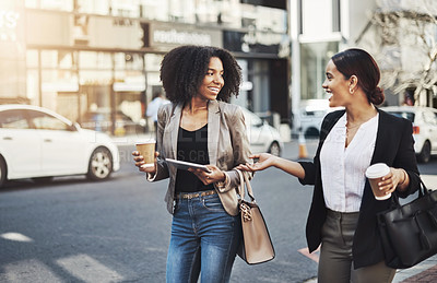 Buy stock photo Shot of two businesswomen having a discussion while walking in the city