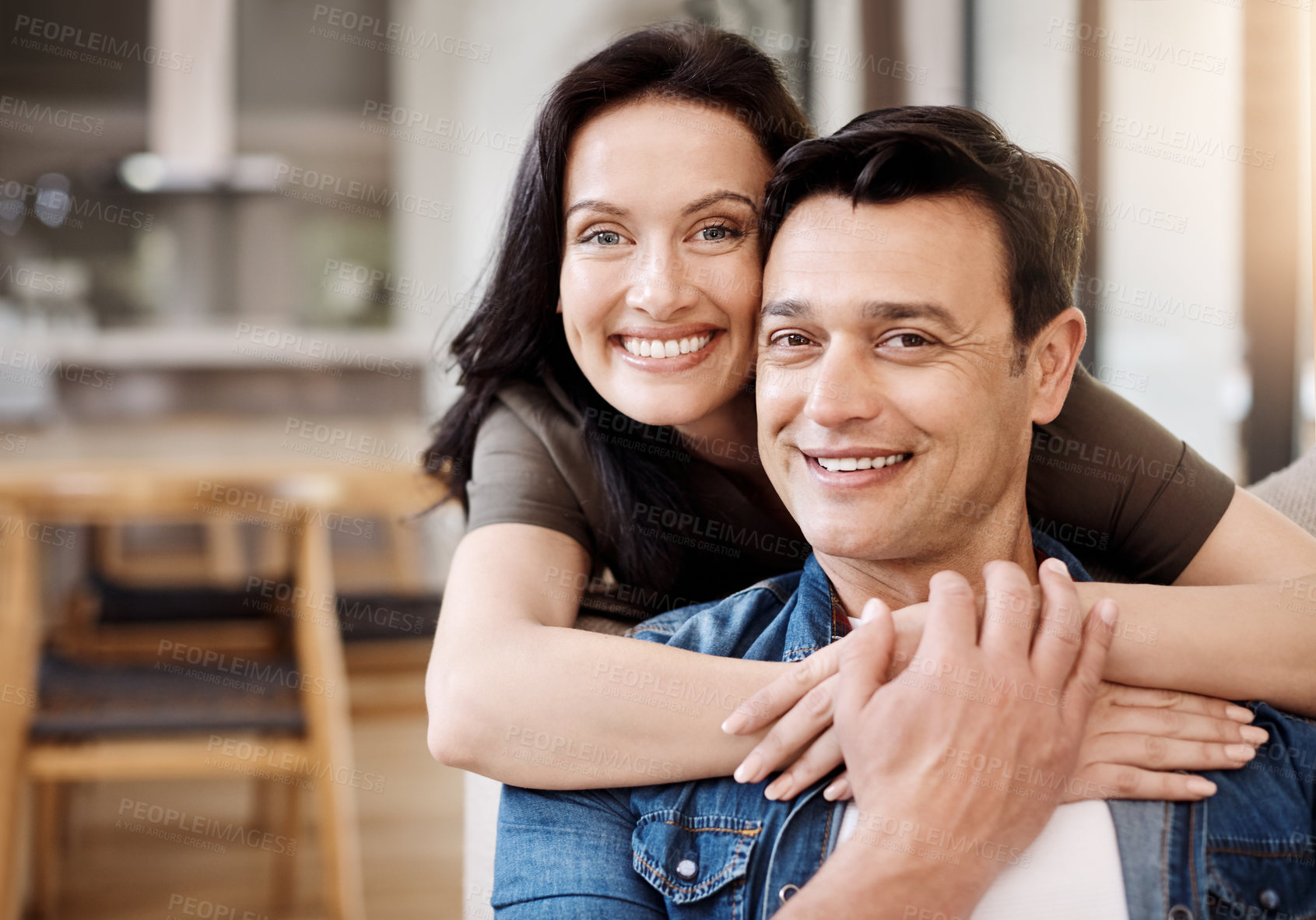 Buy stock photo Shot of a happy young couple embracing at home