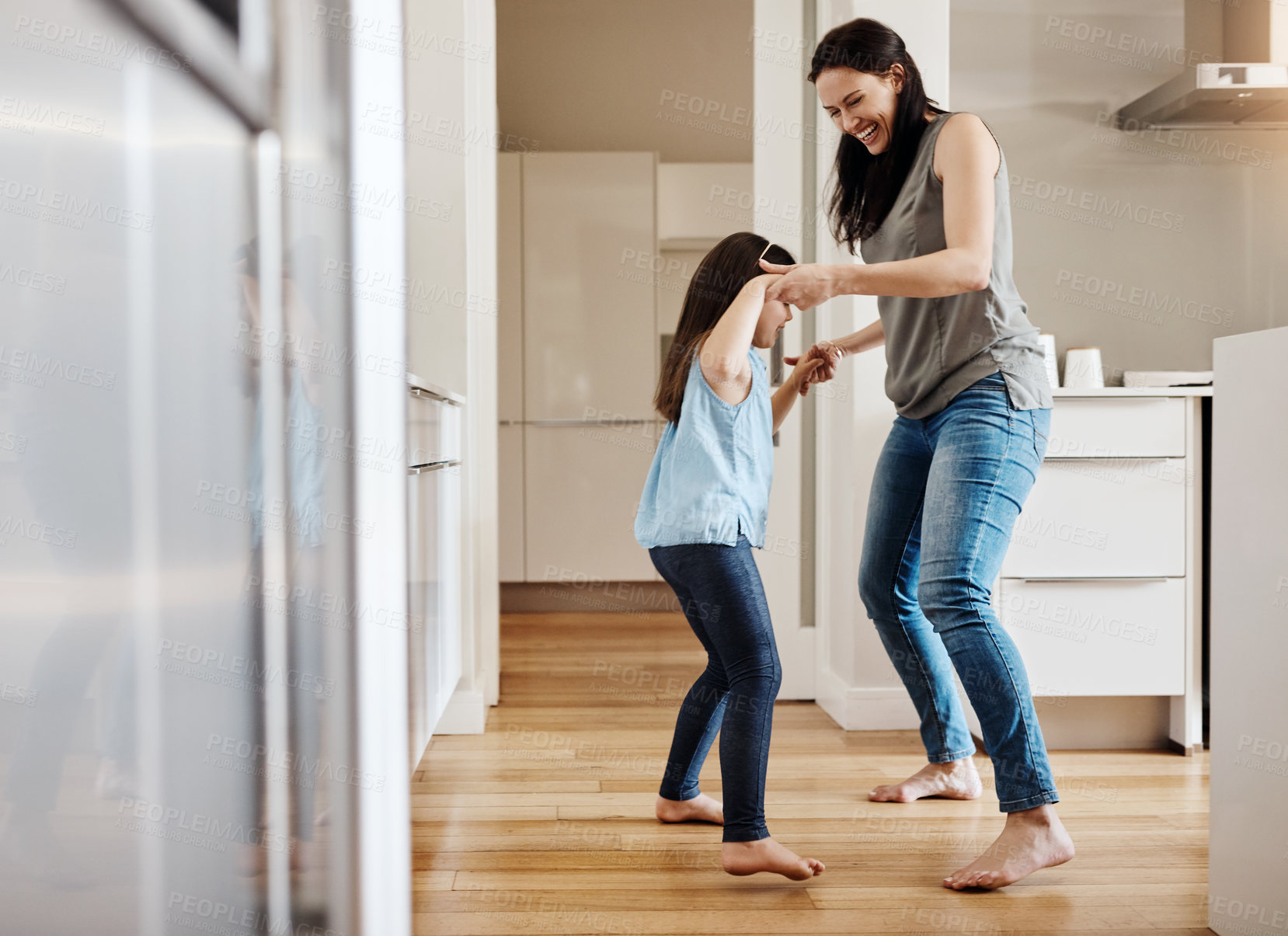 Buy stock photo Holding hands, dance and a child with a mother in the kitchen, bonding and quality time together. Smile, laughing and a mom teaching her daughter with dancing, love and happiness with fun in a house