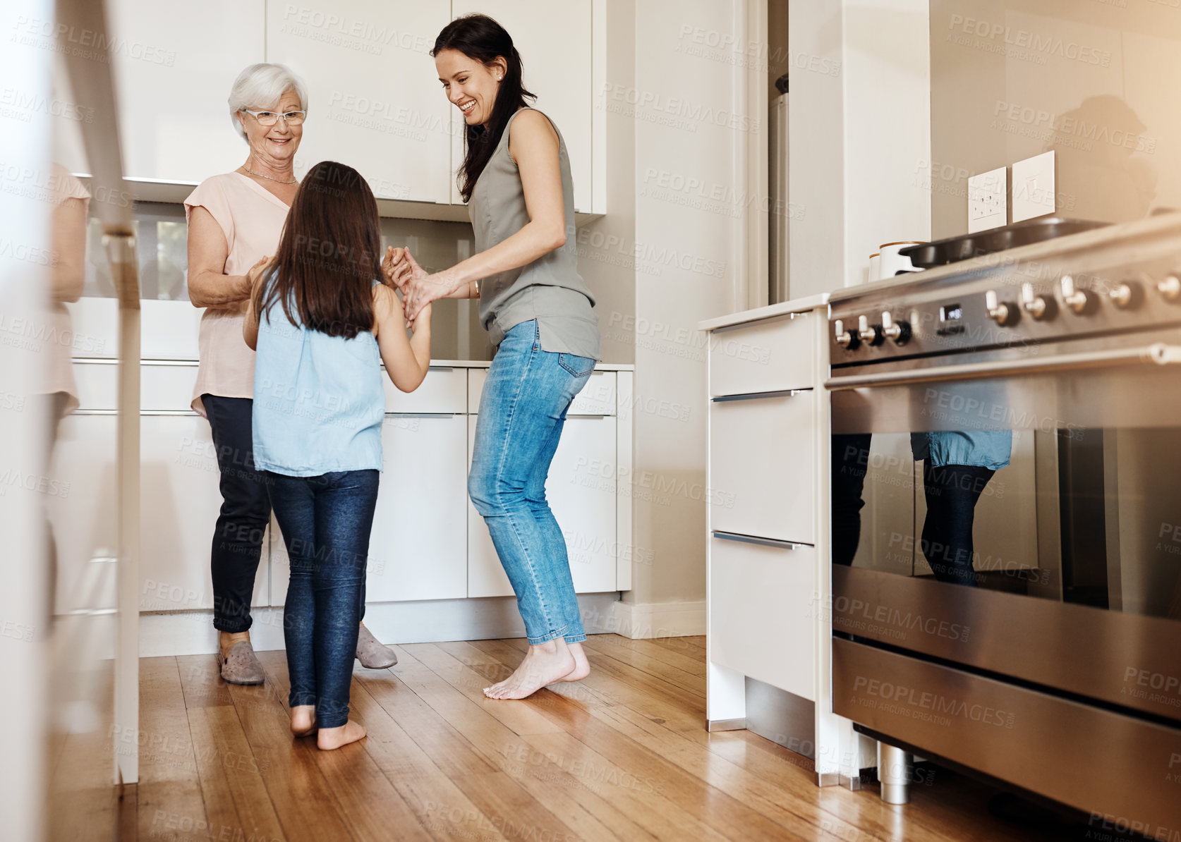 Buy stock photo Shot of an adorable little girl dancing with her mother and granny at home