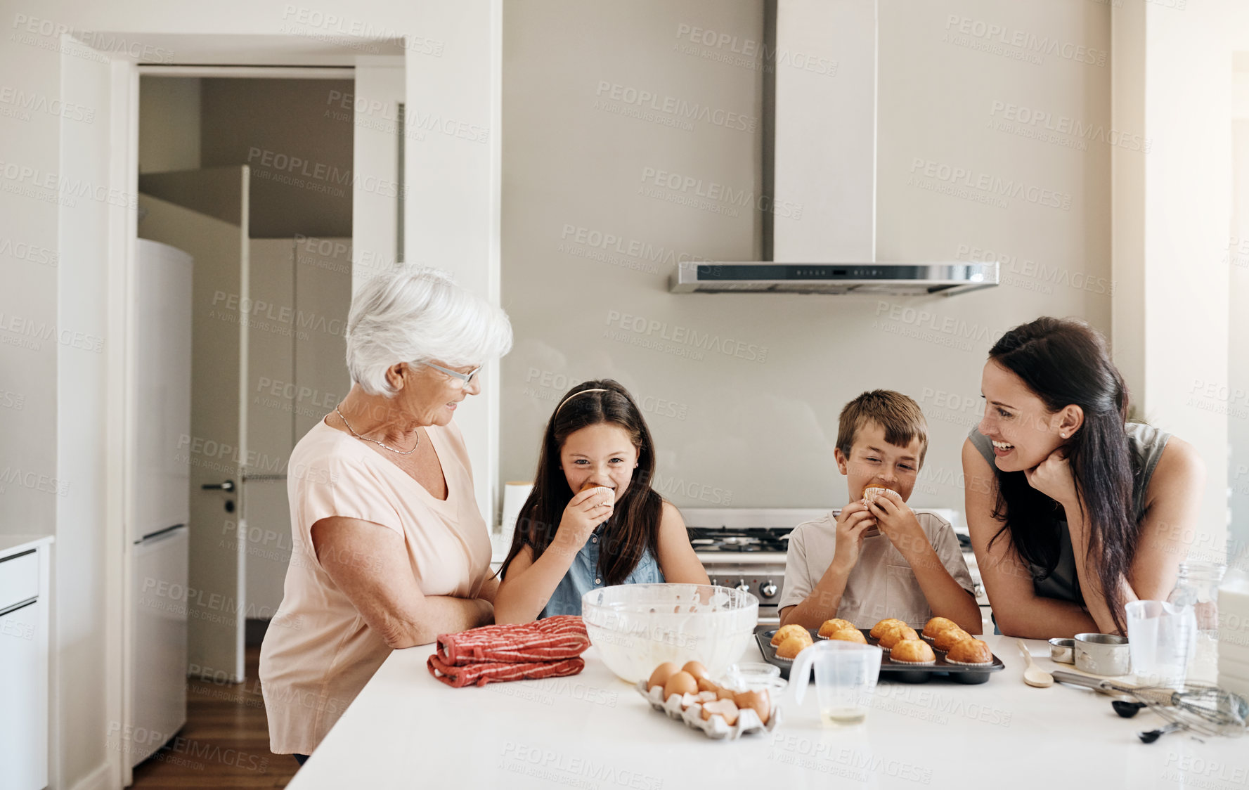 Buy stock photo Shot of a happy three generational family baking muffins together at home
