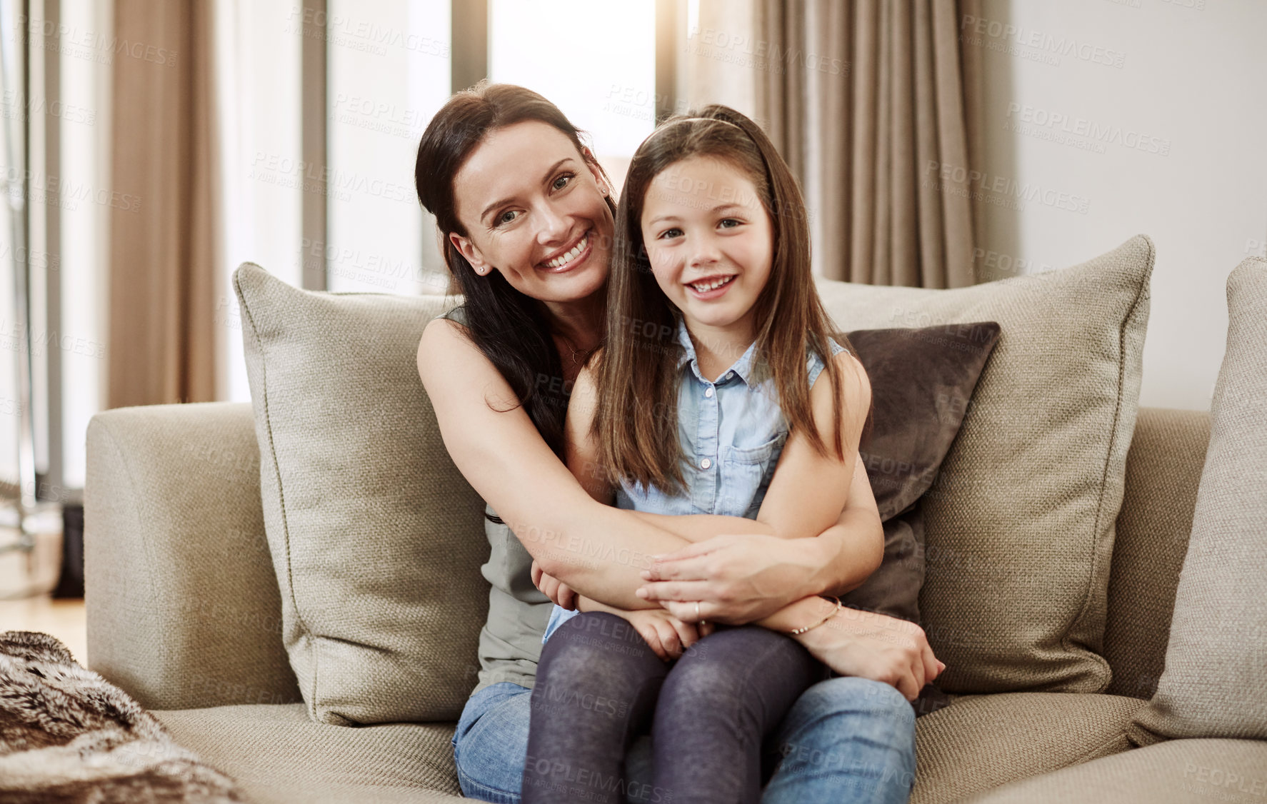 Buy stock photo Shot of an adorable little girl relaxing on the sofa with her mother at home