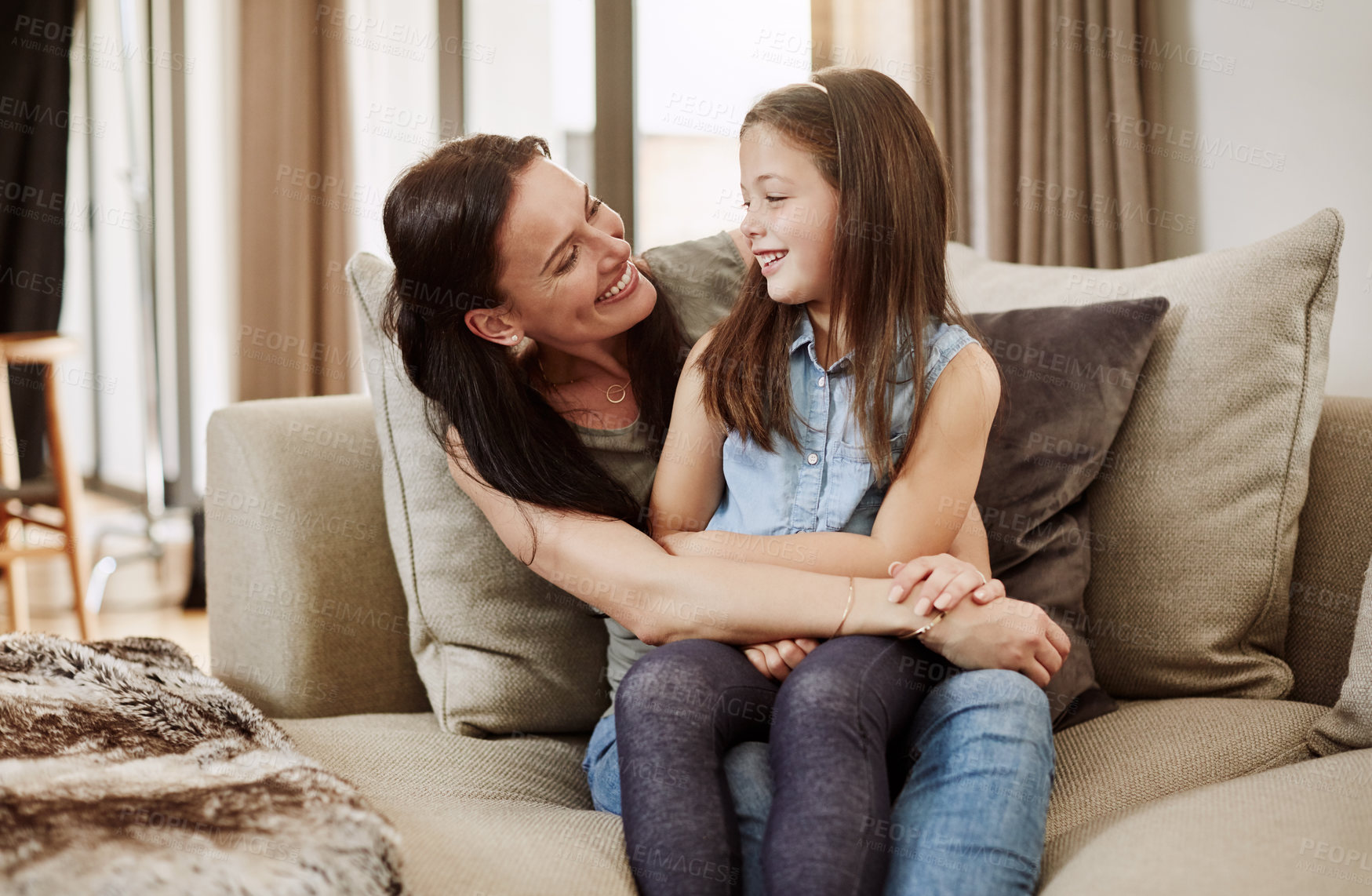 Buy stock photo Shot of an adorable little girl relaxing on the sofa with her mother at home