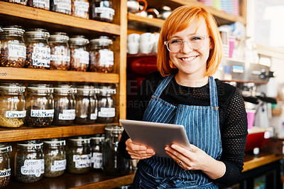 Buy stock photo Shot of a young woman using a digital tablet while working in a coffee shop