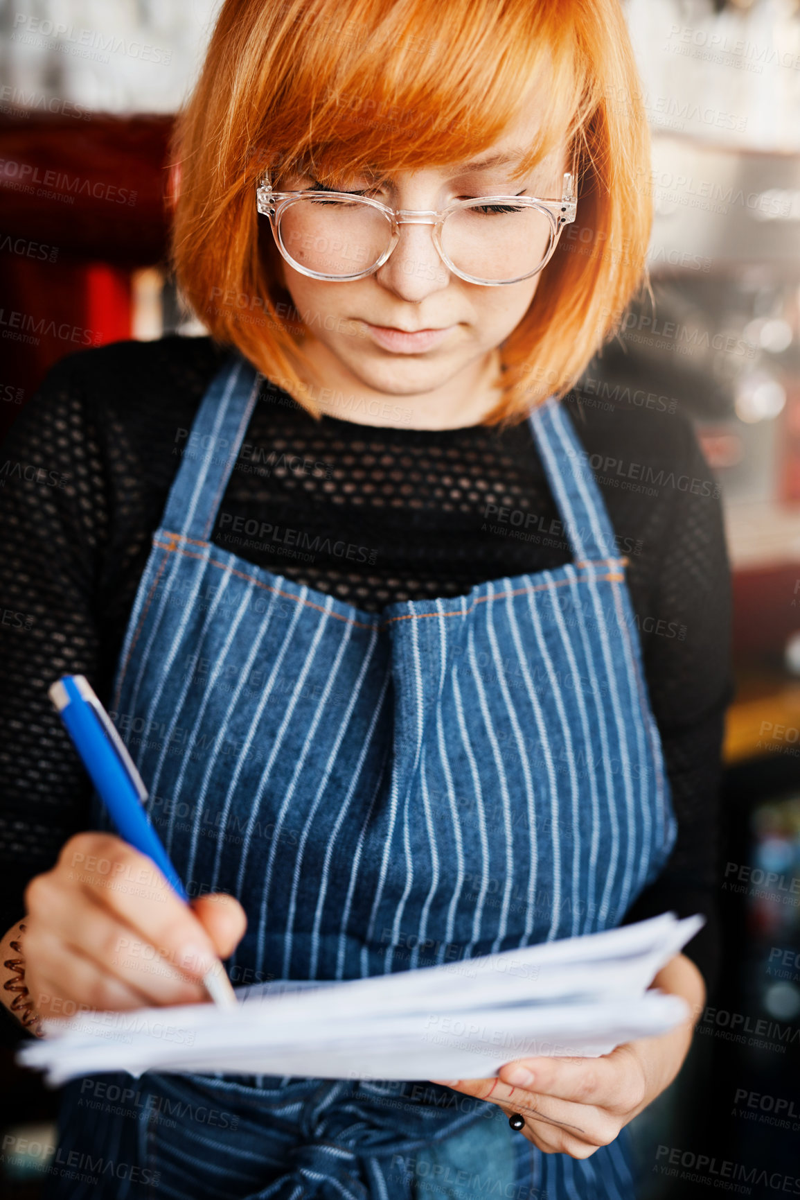 Buy stock photo Startup, woman and writing in cafe for checklist, stock control and feedback in coffee shop. Female barista, restaurant manager and paperwork with pen for schedule, document and inventory in deli