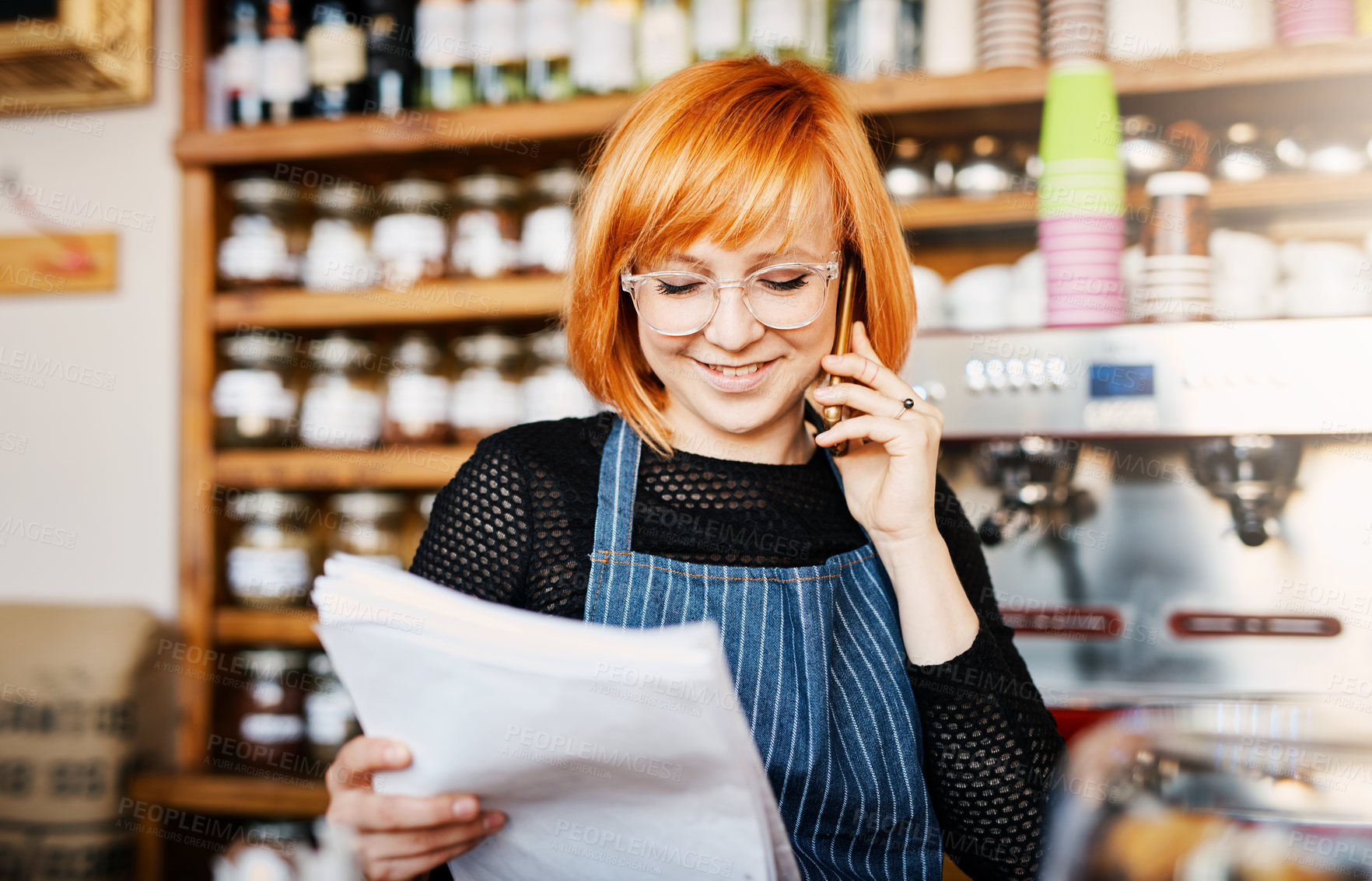 Buy stock photo Woman, business owner and phone call at coffee shop with document, reading or smile for order, stock and deal. Person, smartphone and paperwork for invoice, inventory or contact supplier in cafeteria