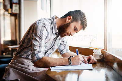 Buy stock photo Coffee shop, writing and man with paperwork for inventory, menu items and stock checklist by window. Restaurant, small business and person with documents for planning, budget review and cafe products