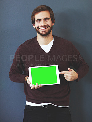 Buy stock photo Studio portrait of a young man holding a digital tablet against a grey background