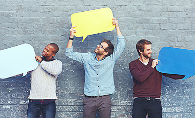 Buy stock photo Shot of a group of young men holding speech bubbles against a brick wall