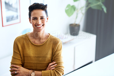 Buy stock photo Cropped portrait of a confident and attractive young businesswoman standing with her arms crossed in an office
