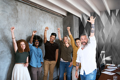 Buy stock photo Cropped portrait of a group of designers raising their fists in unity in a creative office