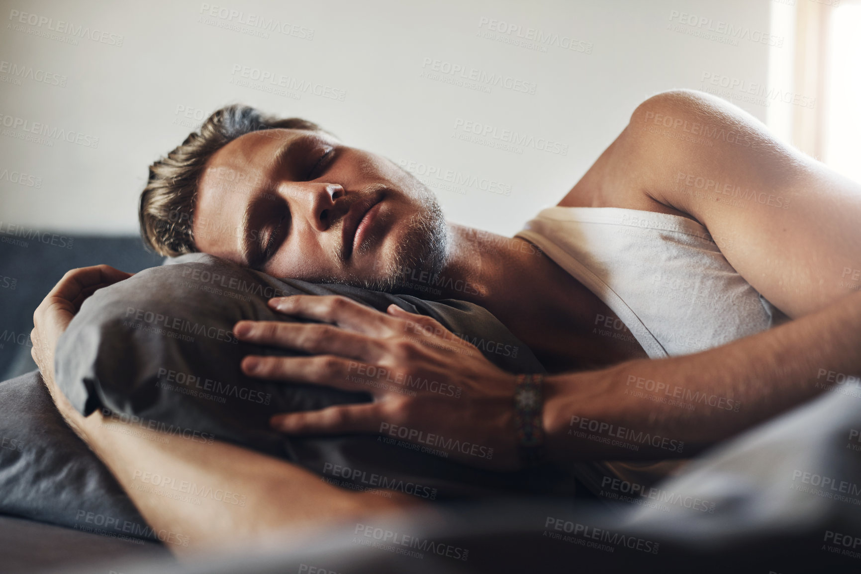 Buy stock photo Shot of a handsome young man sleeping in his bed at home
