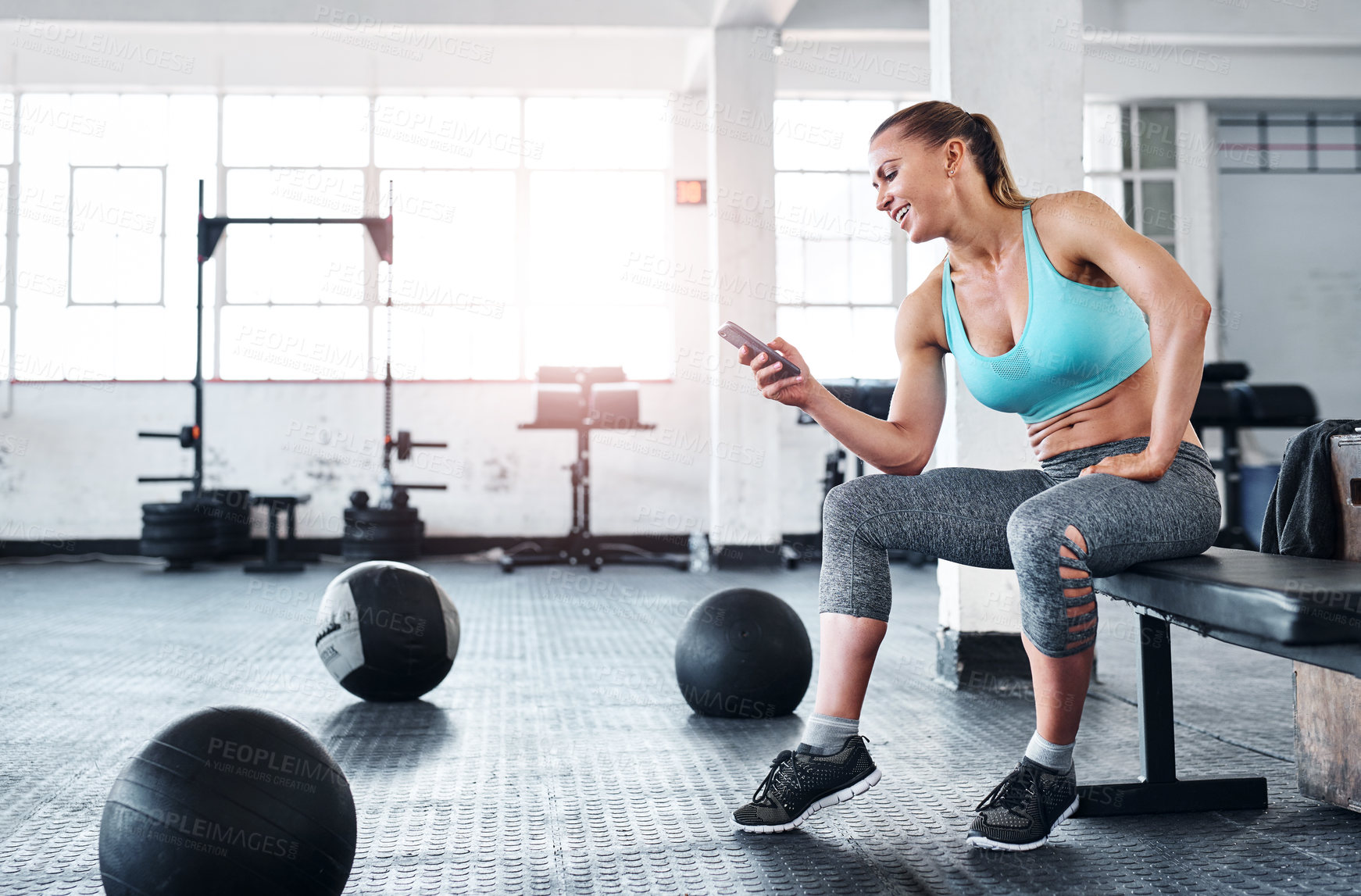 Buy stock photo Shot of a woman using a cellphone in a gym