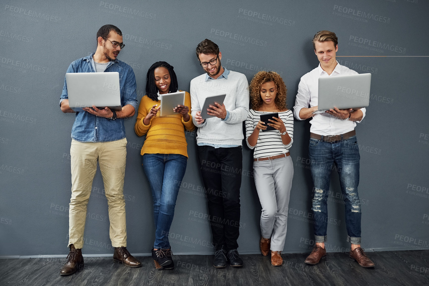 Buy stock photo Full length shot of a group of businesspeople using tablets and notebooks while waiting in line for a job interview