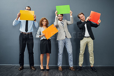 Buy stock photo Full length shot of a group of young creative businesspeople holding up blank placards in their office