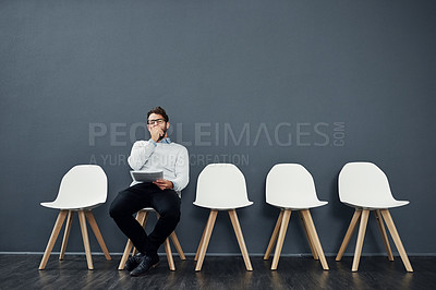 Buy stock photo Cropped shot of a handsome young man yawning while waiting in line for a job interview