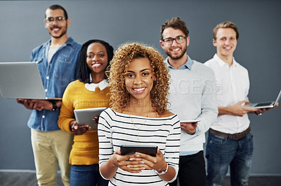 Buy stock photo Studio portrait of a group of businesspeople using wireless technology together while standing in line against a gray background