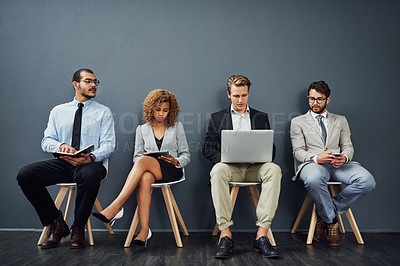 Buy stock photo Business people, technology and waiting room by job interview, recruitment or career opportunity. Group candidate in chair and planning on laptop, tablet and phone or notebook by gray wall background