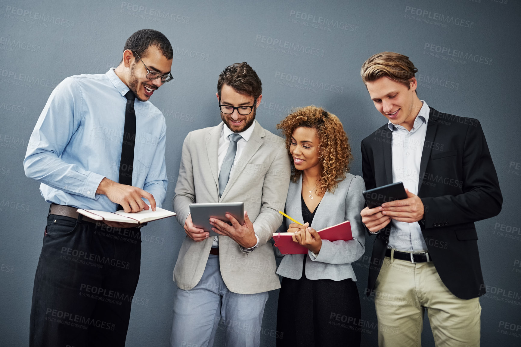 Buy stock photo Cropped shot of a group of businesspeople using digital tablets and notebooks while waiting in line for a job interview