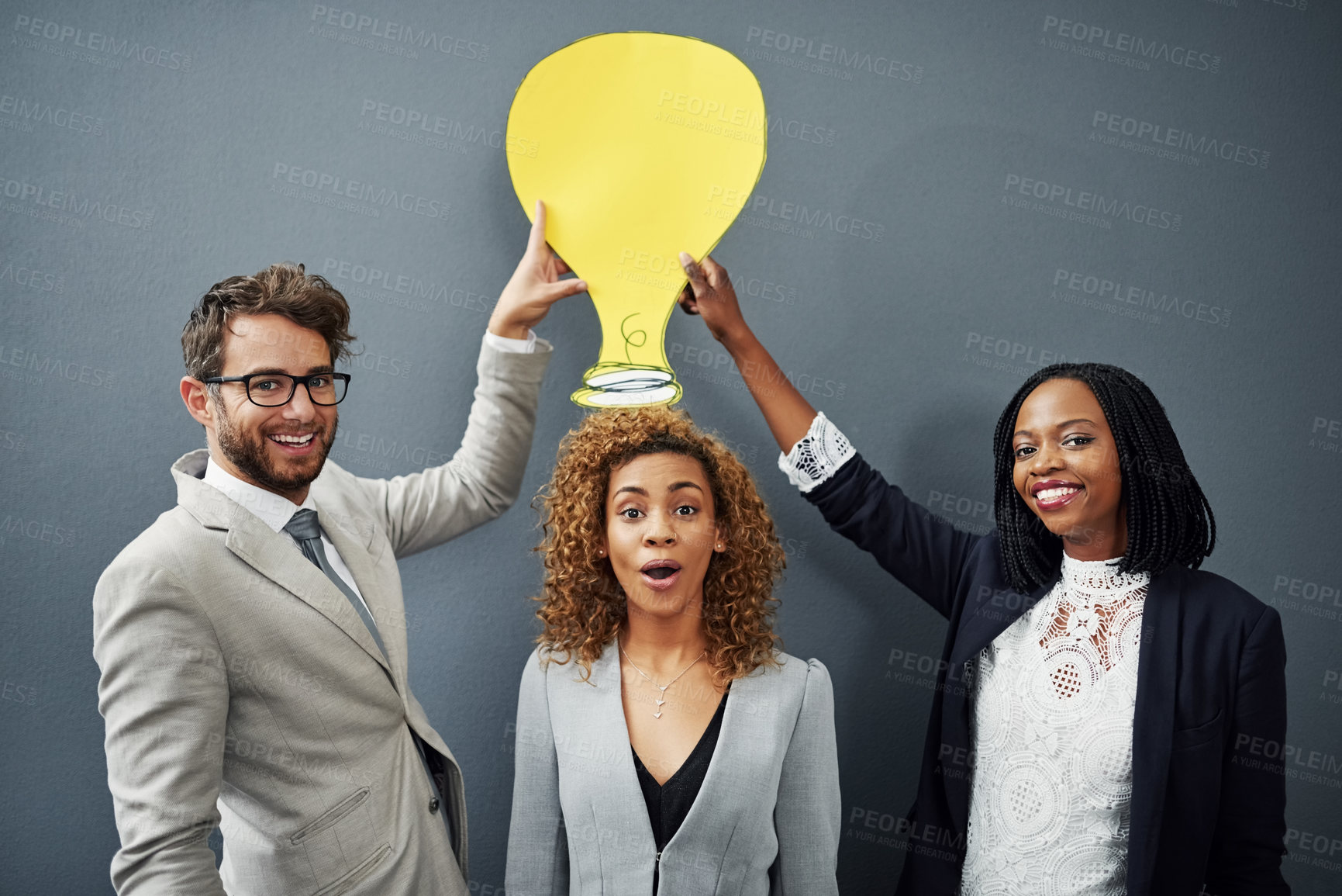 Buy stock photo Portrait, business people and poster with lightbulb, ideas and group on gray studio background. Face, employees and coworkers with cardboard, inspiration or planning with brainstorming or cooperation