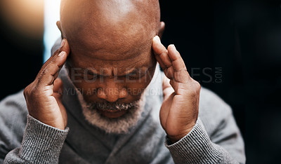 Buy stock photo Shot of a handsome senior man rubbing his temples in pain