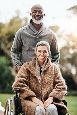 Buy stock photo Shot of an elderly man pushing his wife in her wheelchair outside their home
