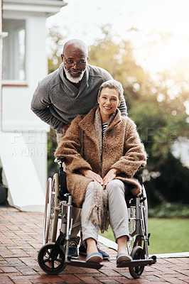 Buy stock photo Shot of an elderly man pushing his wheelchair-bound wife around the yard at home