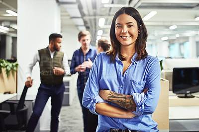 Buy stock photo Portrait of a young designer standing in an office with her colleagues in the background