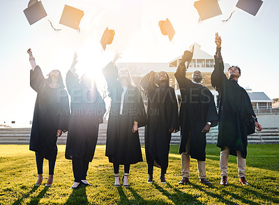 Buy stock photo Shot of a group of students throwing their hats in the air on graduation day