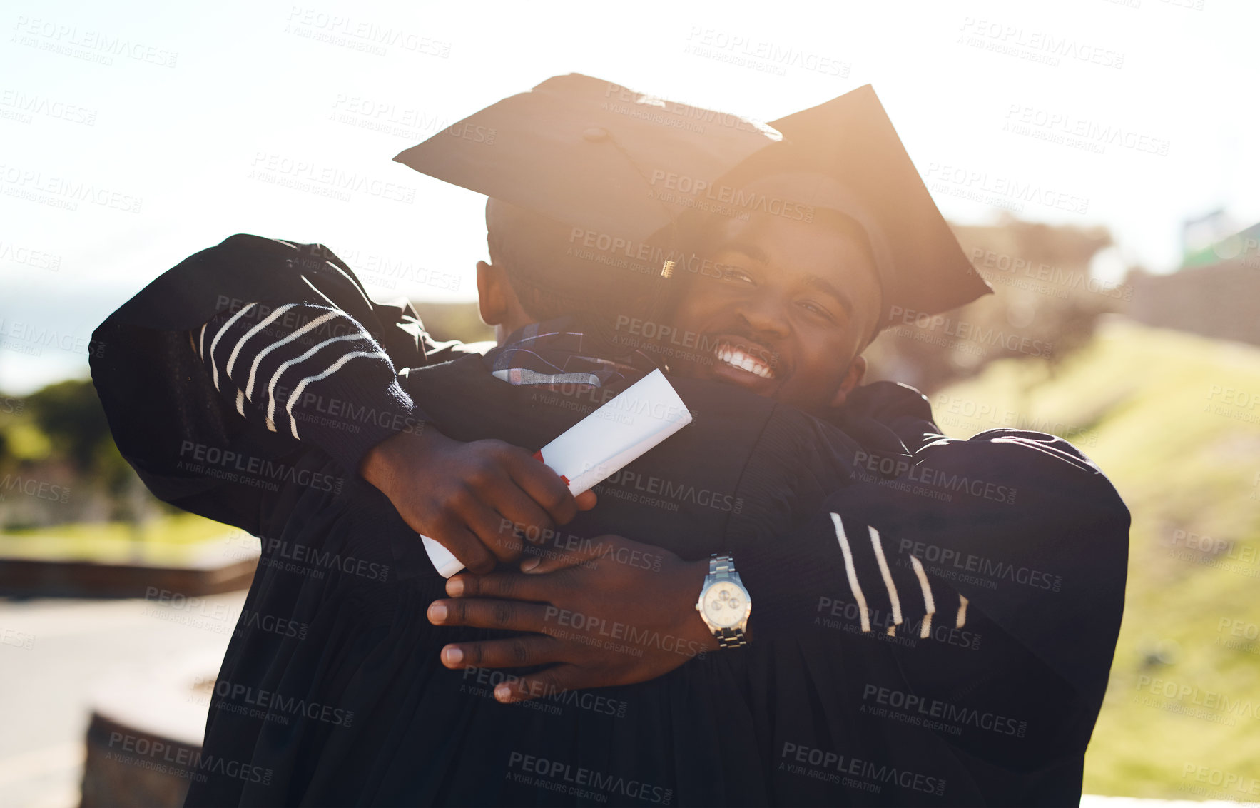 Buy stock photo Shot of two happy young students hugging each other on graduation day