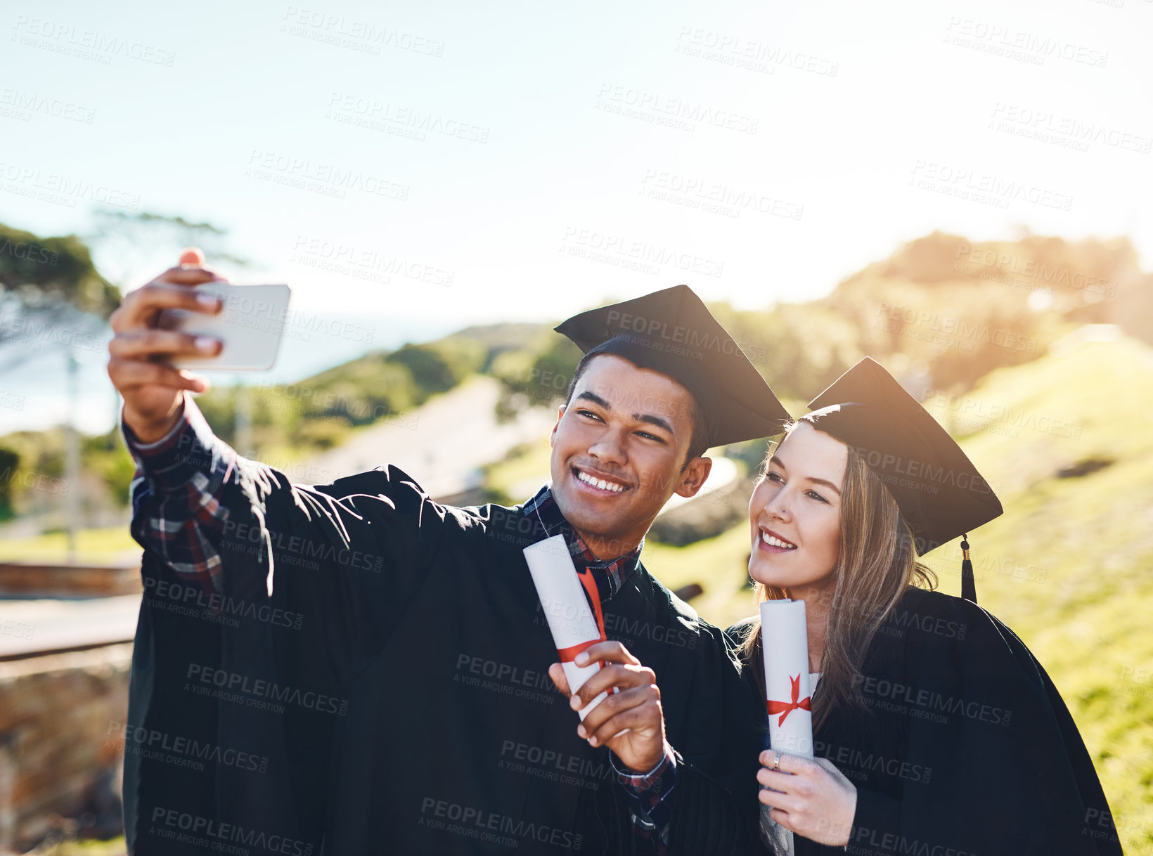Buy stock photo Cropped shot of two students taking a selfie on graduation day