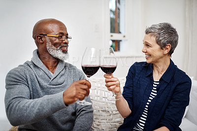 Buy stock photo Shot of an affectionate senior couple enjoying some wine together at home