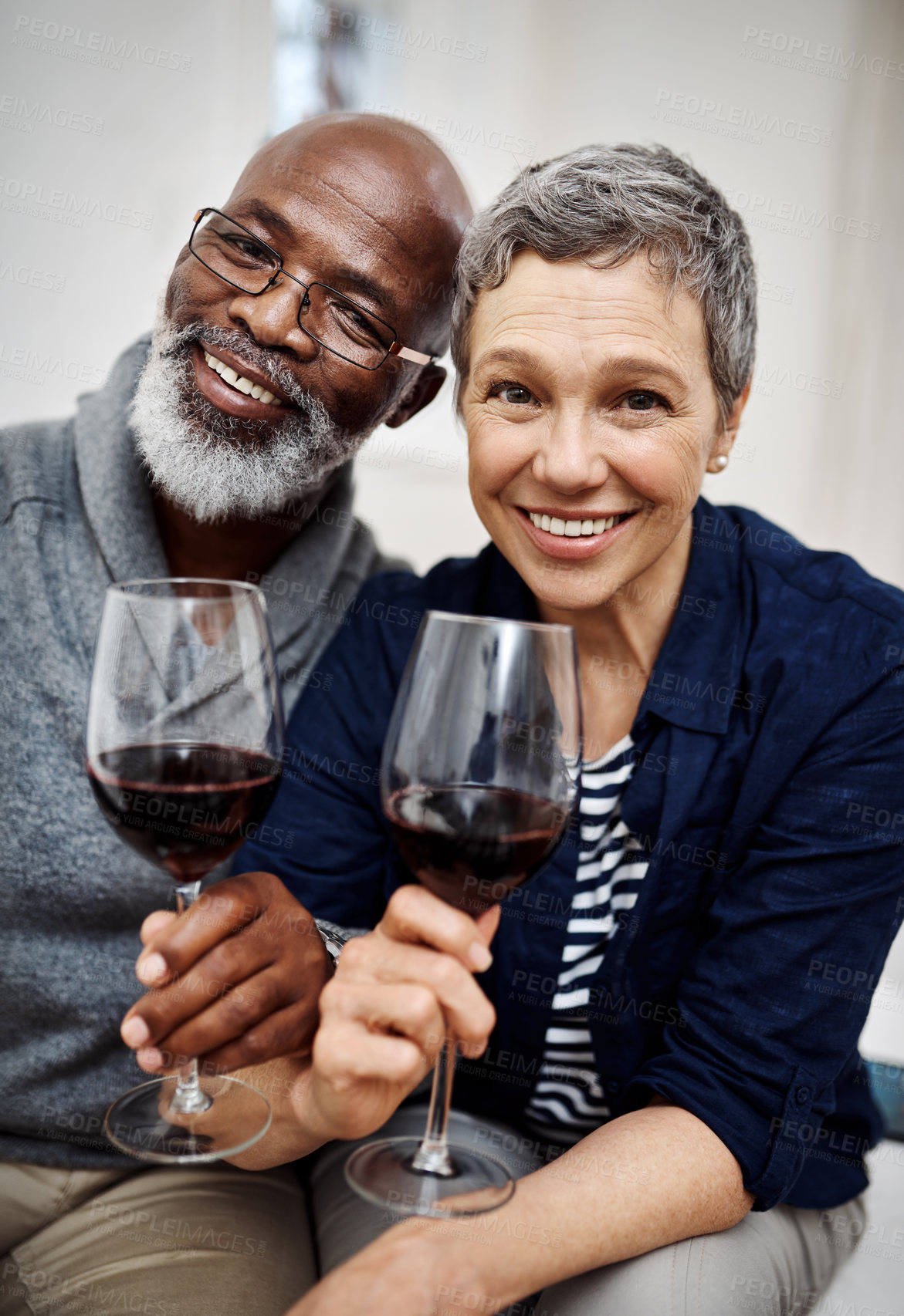 Buy stock photo Shot of an affectionate senior couple enjoying some wine together at home