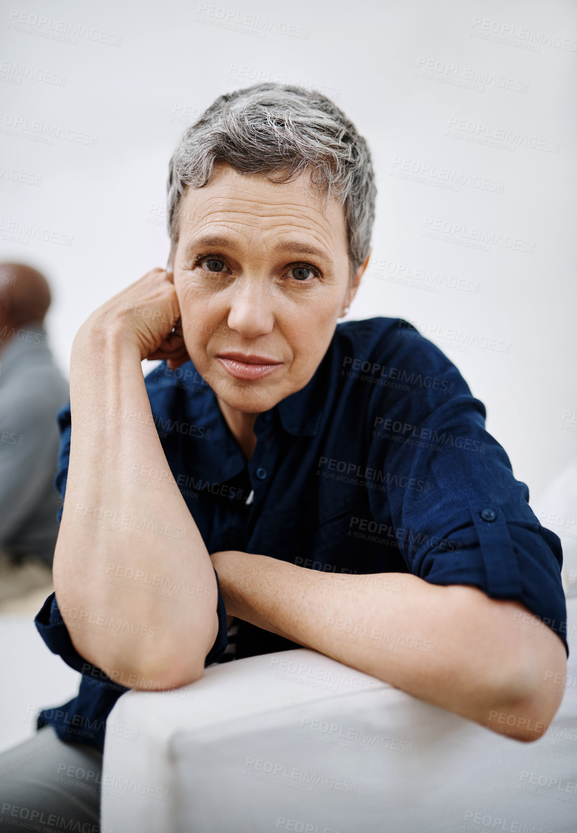 Buy stock photo Closeup shot of an unhappy senior women posing with her husband in the background at home