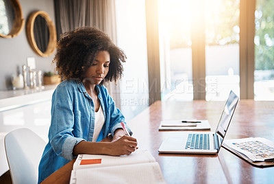 Buy stock photo Shot of an attracting young woman writing notes on a book at home