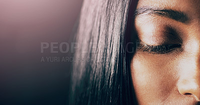 Buy stock photo Closeup shot of a beautiful young woman posing with her eyes closed against a dark background
