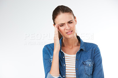 Buy stock photo Studio shot of a young woman suffering from a headache against a grey background