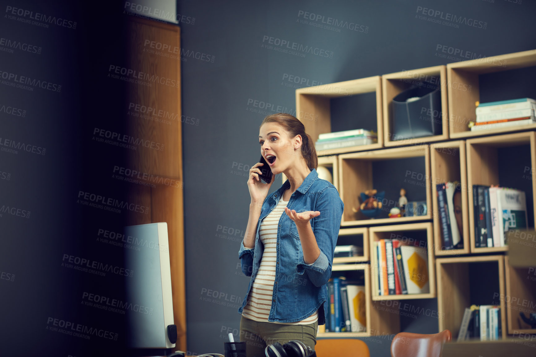 Buy stock photo Shot of a young businesswoman using a mobile phone and looking surprised in a modern office