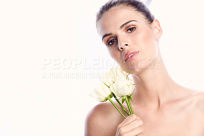 Buy stock photo Studio shot of a beautiful young woman posing with white roses against her face