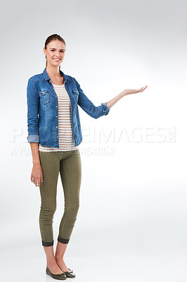 Buy stock photo Studio portrait of an attractive young woman presenting copy space against a grey background