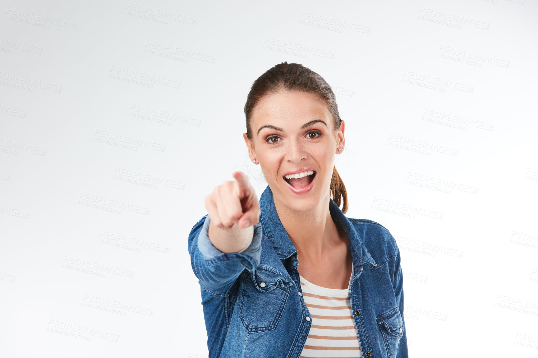 Buy stock photo Studio portrait of a young woman pointing against a grey background