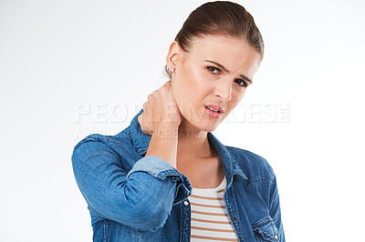 Buy stock photo Studio portrait of a young woman suffering from neck pain against a grey background