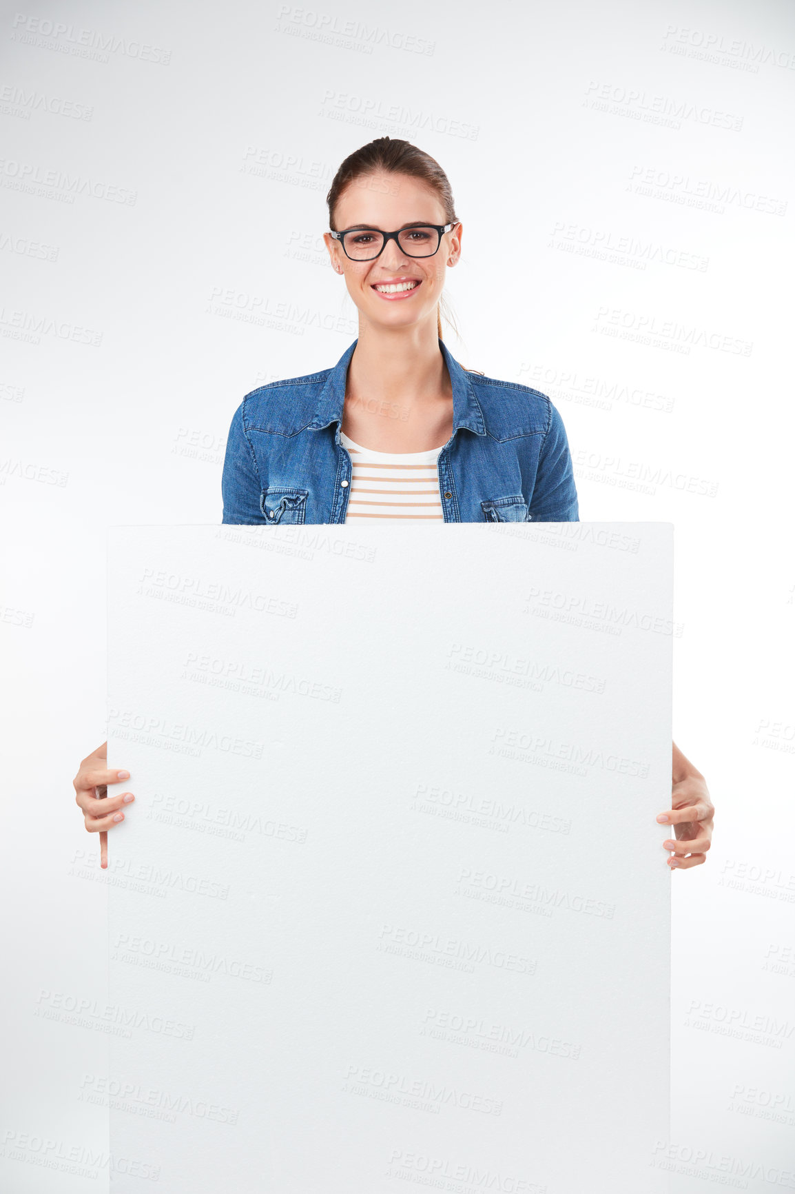 Buy stock photo Studio portrait of a young woman holding a blank placard against a grey background