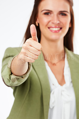 Buy stock photo Studio portrait of a young woman showing a thumbs up gesture against a grey background