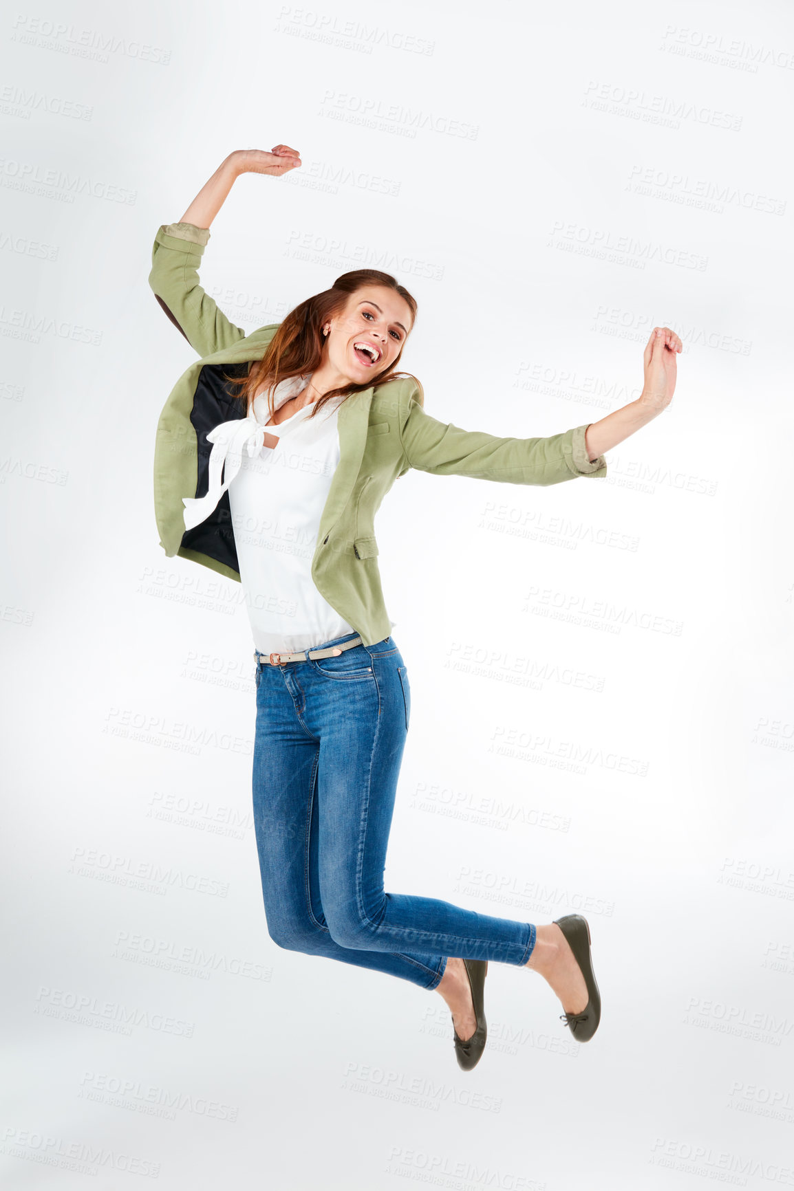 Buy stock photo Studio portrait of a happy young woman jumping for joy against a grey background